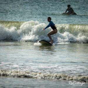 Learn to surf in Kuta Lombok beginner riding small wave during surf lesson in Mandalika