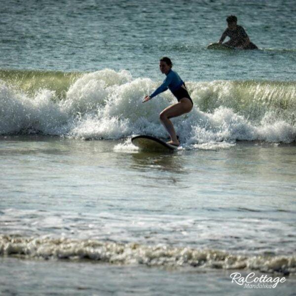 Learn to surf in Kuta Lombok beginner riding small wave during surf lesson in Mandalika