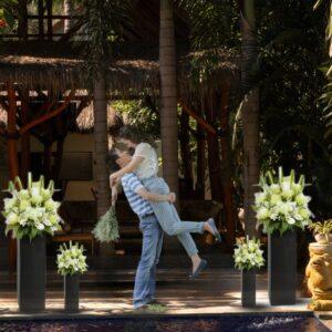Pre-wedding package Mandalika intimate garden ceremony couple romantic lift moment with tropical flowers at RaCottage Lombok