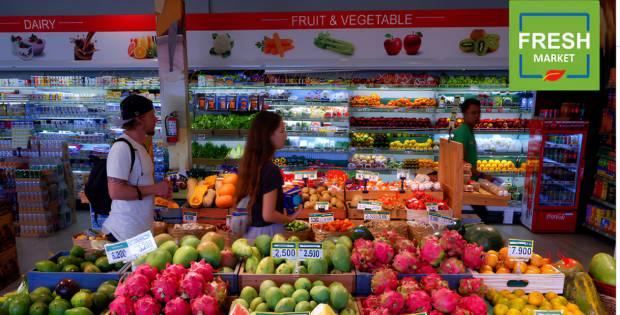 People shopping for fresh fruits and vegetables inside Freshmarket in Kuta Lombok with colorful produce displays and grocery aisles