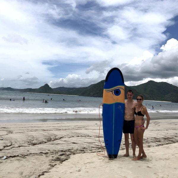Surfing in Gerupuk Bay Lombok with surfers holding a board on the beach before a session