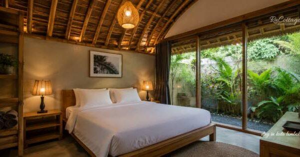 Where to stay in Kuta Lombok cozy tropical bedroom villa with curved bamboo ceiling, wooden bed, warm lighting, and lush garden view near Kuta Center