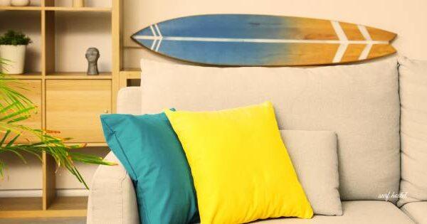 Interior of a surf hostel in Kuta Lombok with colorful cushions and surfboard decor, illustrating the lifestyle difference between a surf hostel and a private room.