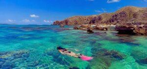 Snorkeler exploring one of the best snorkeling spots near Kuta Lombok with crystal-clear water and vibrant coral reefs.